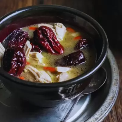Bowl of health soup with goji berries, chicken and dried red dates.